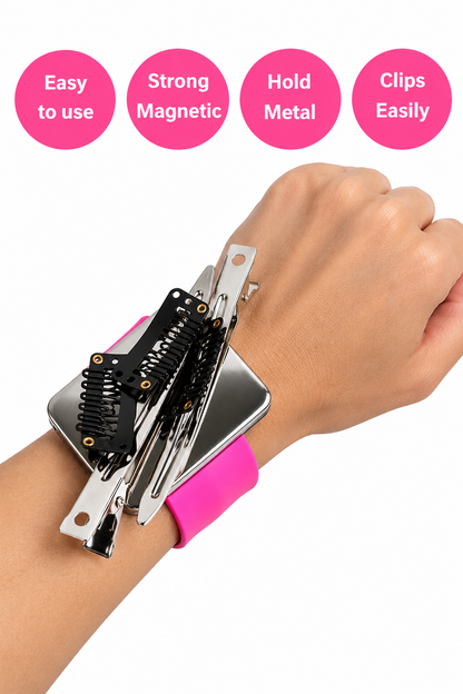 A close-up of a person's wrist and hand wearing a pink wristband with a metal clip device attached, showing several black and silver metal clips held in place. Four pink circles at the top read 'Easy to use', 'Strong Magnetic', 'Hold Metal', and 'Clips Easily'.